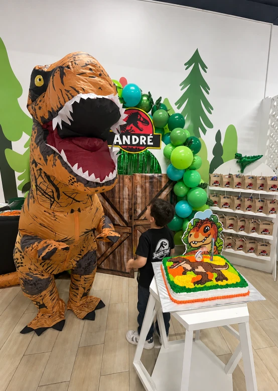Niño junto a un disfraz inflable de dinosaurio en una fiesta temática