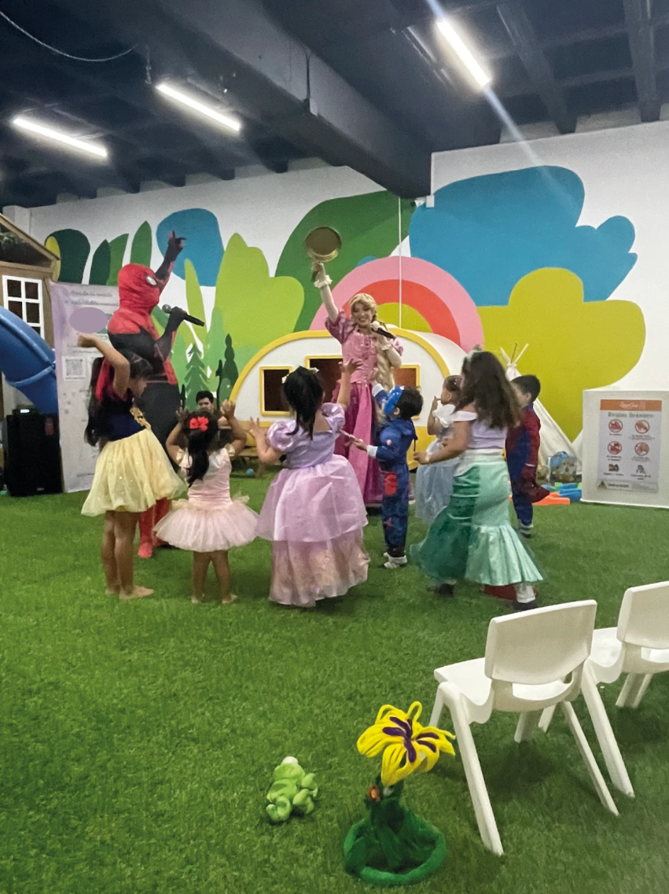 Niños disfrazados bailando en el pasto con sus personajes